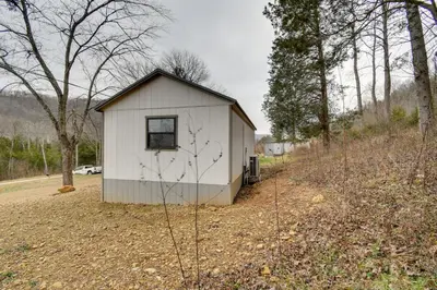 a small white shed sitting on the side of a road at Stout Cabin with Fire Pit 1 Mi to Ohio River! in Stout
