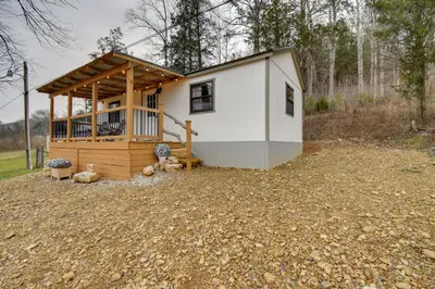a tiny house with a porch and a deck at Stout Cabin with Fire Pit 1 Mi to Ohio River! in Stout