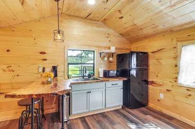 a kitchen with a counter and a refrigerator at Stout Cabin with Fire Pit 1 Mi to Ohio River! in Stout