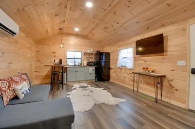a living room with a couch and a tv at Stout Cabin with Fire Pit 1 Mi to Ohio River! in Stout