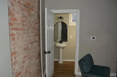 a bathroom with a sink and a brick wall at Eco Friendly Home by Cincy w Office Space in Dayton