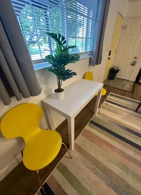 a room with a table and yellow chairs and a potted plant at Nationwide Childrens Hospital close by in Columbus