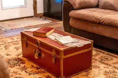a trunk with a book on top of it next to a couch at Whispering Pines Retreat in Zuck