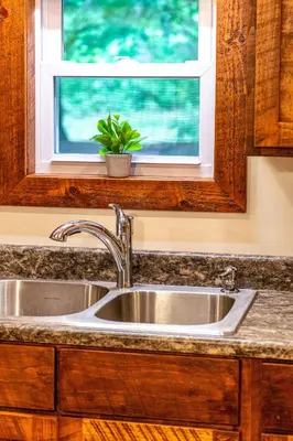 a kitchen sink with a potted plant under a window at Whispering Pines Retreat in Zuck