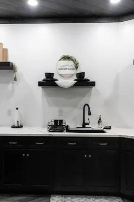 a kitchen with black cabinets and a sink at Harvest Haven in Seaman