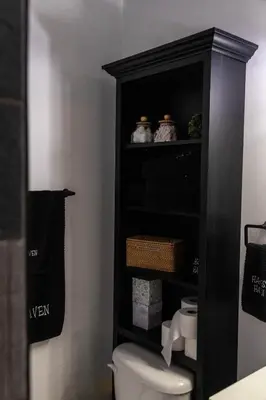 a bathroom with a toilet in a black cabinet at Harvest Haven in Seaman