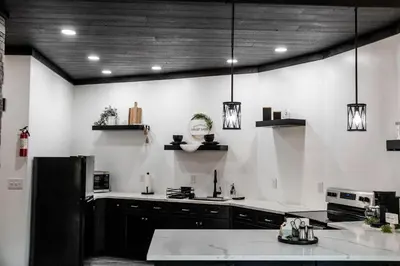 a kitchen with black cabinets and white walls at Harvest Haven in Seaman