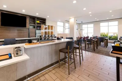a restaurant with a bar with chairs and tables at The Hilton Garden Inn in Grove City