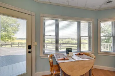 a dining room with a table and two windows at 4 Mi to German Village Studio with Hot Tub! in Millersburg