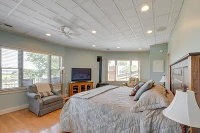 a bedroom with a large bed and a tv at 4 Mi to German Village Studio with Hot Tub! in Millersburg