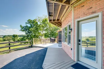 an open door on a brick house with a porch at 4 Mi to German Village Studio with Hot Tub! in Millersburg