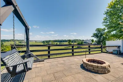 a porch with a swing and a fire pit at 4 Mi to German Village Studio with Hot Tub! in Millersburg