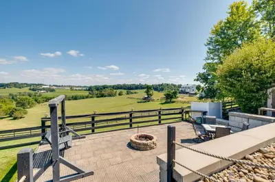 a patio with benches and a fire pit and a fence at Panoramic Views Hillside Millersburg Studio in Millersburg