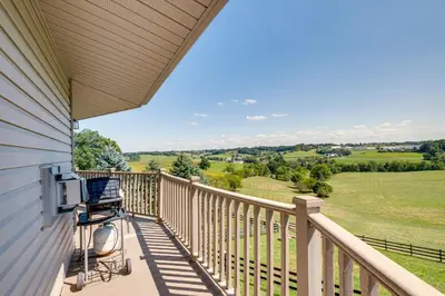 a rocking chair on a porch with a view of the countryside at Panoramic Views Hillside Millersburg Studio in Millersburg