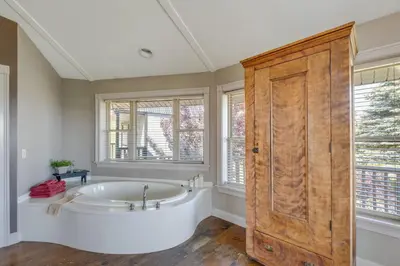 a bathroom with a tub and a wooden door at Panoramic Views Hillside Millersburg Studio in Millersburg