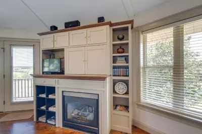 a fireplace in a living room with windows and a mantle at Millersburg Getaway with Amish Country Views! in Millersburg