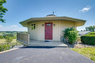 a small yellow house with a red door at Millersburg Getaway with Amish Country Views! in Millersburg
