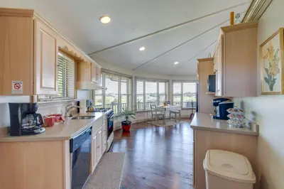 a large kitchen with wooden cabinets and a living room at Millersburg Getaway with Amish Country Views! in Millersburg