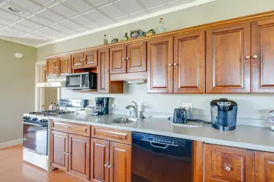 a kitchen with wooden cabinets and a sink at Holmes With a View Studio Millersburg Retreat! in Millersburg