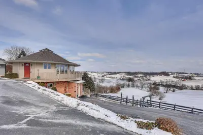 a house on the side of a road in the snow at Holmes With a View Studio Millersburg Retreat! in Millersburg