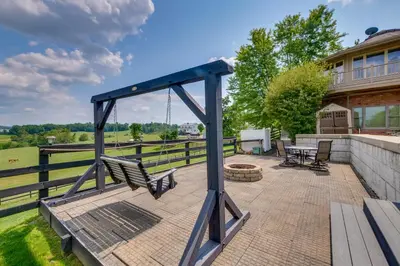 a swing on a patio in front of a house at Amish Country Getaway with Pastoral Views! in Millersburg