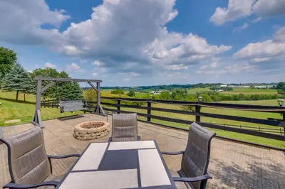 a patio with a table and chairs and a fire pit at Amish Country Getaway with Pastoral Views! in Millersburg