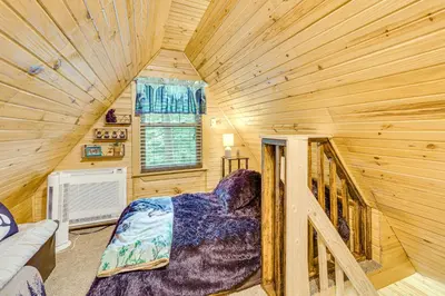 a bedroom with a bed in a log cabin at Carrollton Cabin with Patio and Fire Pit! in Carrollton