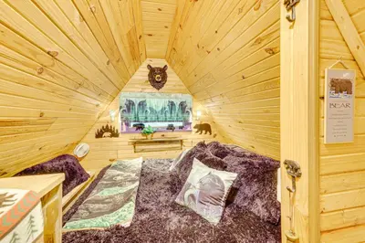 a room with a bed in a wooden cabin at Carrollton Cabin with Patio and Fire Pit! in Carrollton
