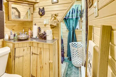 a bathroom with a sink and a toilet in a trailer at Carrollton Cabin with Patio and Fire Pit! in Carrollton