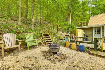 a backyard with chairs and a fire pit and a house at Carrollton Cabin with Patio and Fire Pit! in Carrollton