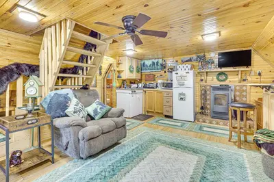 a living room with a couch and a kitchen at Carrollton Cabin with Patio and Fire Pit! in Carrollton