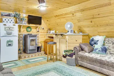 a living room with a couch and a refrigerator at Carrollton Cabin with Patio and Fire Pit! in Carrollton