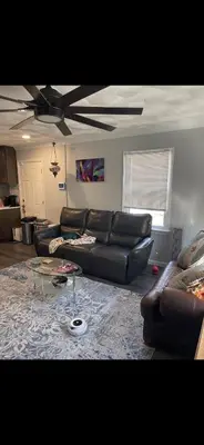 a living room with a leather couch and a table at Very affordable Spacious private urban oasis in Cincinnati