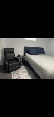 a bedroom with a bed and a chair at Very affordable Spacious private urban oasis in Cincinnati