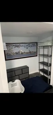a room with a window and a bed and a shelf at Very affordable Spacious private urban oasis in Cincinnati