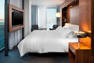 a hotel room with a large bed and a tv at Le Meridien Columbus, The Joseph in Columbus