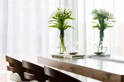 three vases with flowers on a table in a window at Le Meridien Columbus, The Joseph in Columbus