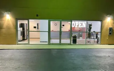 a store front with a open sign in the windows at Value Stay in Winchester