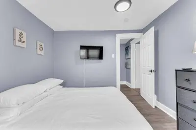 a bedroom with a white bed and a tv at Quaint 2 Bedrooms in Historic Little Italy in Ambler Heights