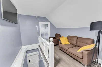 a living room with a couch and a staircase at Quaint 2 Bedrooms in Historic Little Italy in Ambler Heights