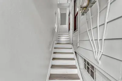 a stairway in a building with white walls and white stairs at Quaint 2 Bedrooms in Historic Little Italy in Ambler Heights