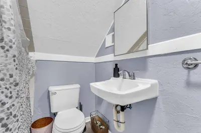 a bathroom with a white toilet and a sink at Quaint 2 Bedrooms in Historic Little Italy in Ambler Heights