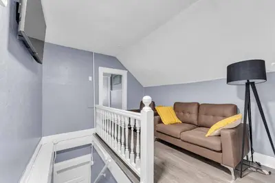 a living room with a couch and a staircase at Quaint 2 Bedrooms in Historic Little Italy in Ambler Heights