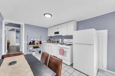 a kitchen with a table and a white refrigerator at Quaint 2 Bedrooms in Historic Little Italy in Ambler Heights