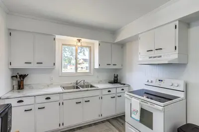 a white kitchen with white cabinets and a sink at Waterfront Port Clinton Cottage 5 Mi to Lake Erie in Port Clinton