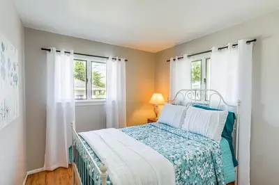 a bedroom with a bed and two windows at Waterfront Port Clinton Cottage 5 Mi to Lake Erie in Port Clinton