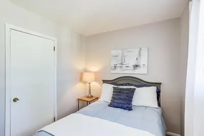 a white bedroom with a bed with a blue pillow at Waterfront Port Clinton Cottage 5 Mi to Lake Erie in Port Clinton
