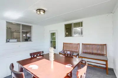 a dining room with a wooden table and benches at Waterfront Port Clinton Cottage 5 Mi to Lake Erie in Port Clinton
