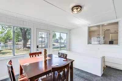 a dining room with a table and chairs and windows at Waterfront Port Clinton Cottage 5 Mi to Lake Erie in Port Clinton