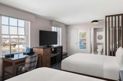 a hotel room with two beds and a desk with a television at The Well House Hamilton, Tapestry Collection By Hilton in Hamilton